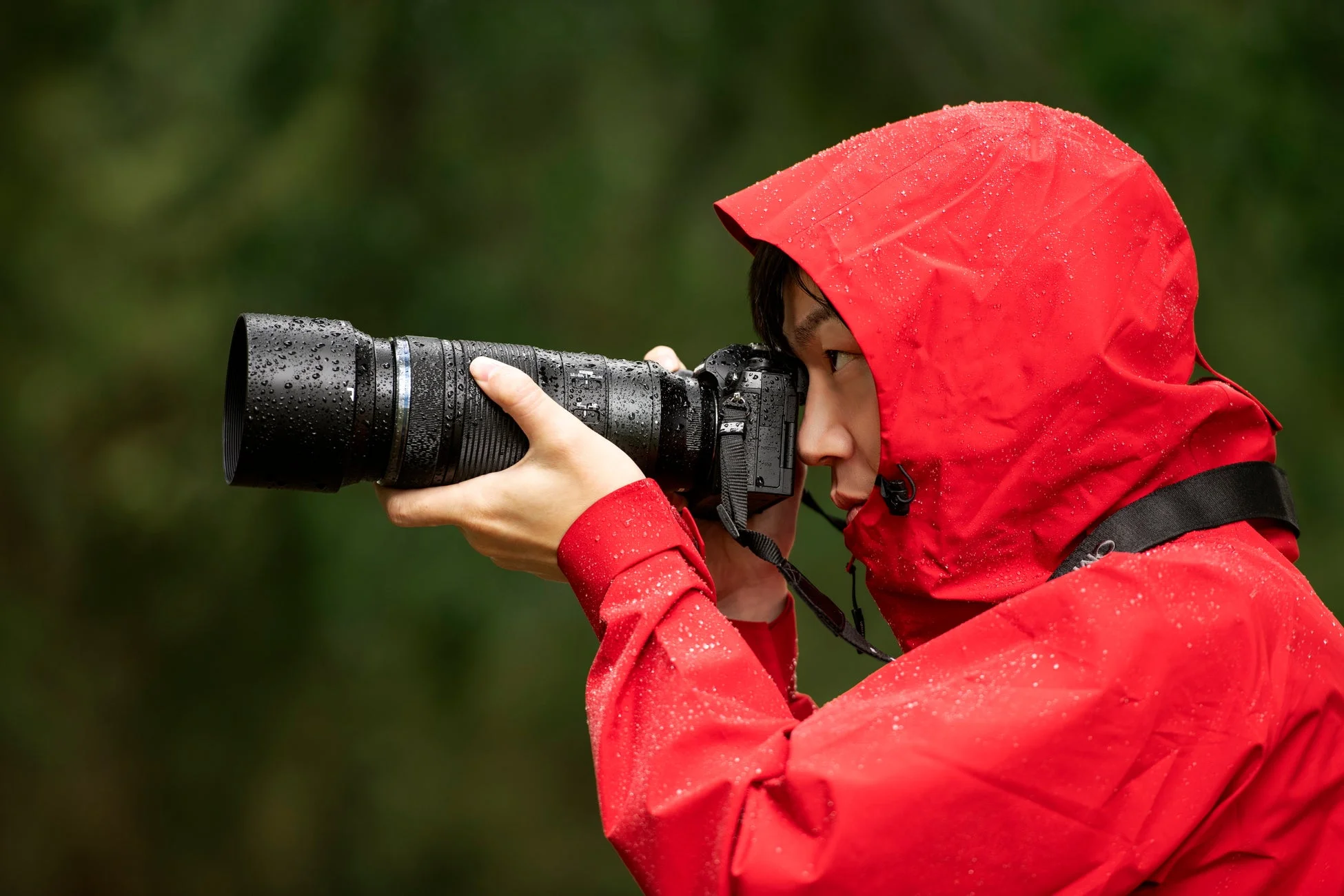 雨の中で撮影するカメラマン