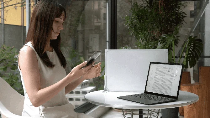 スマホを壁に固定して作業する女性