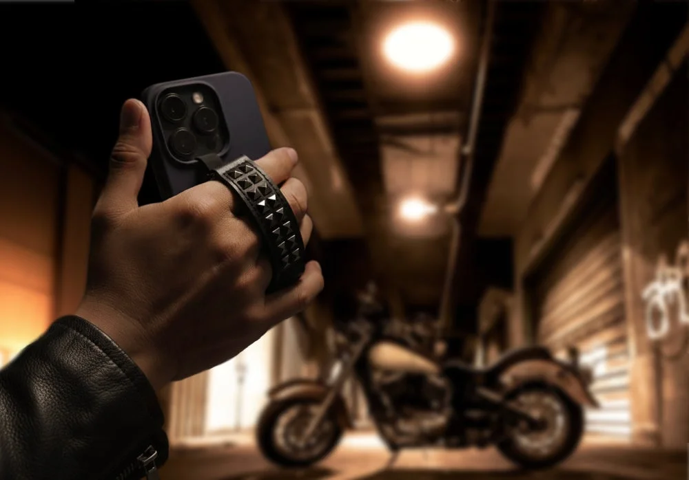 ライダースジャケットの人物とスマホ