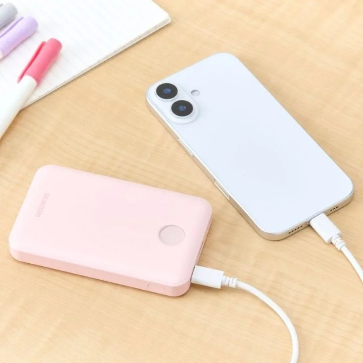 ピンクのモバイルバッテリーでスマートフォンを充電中