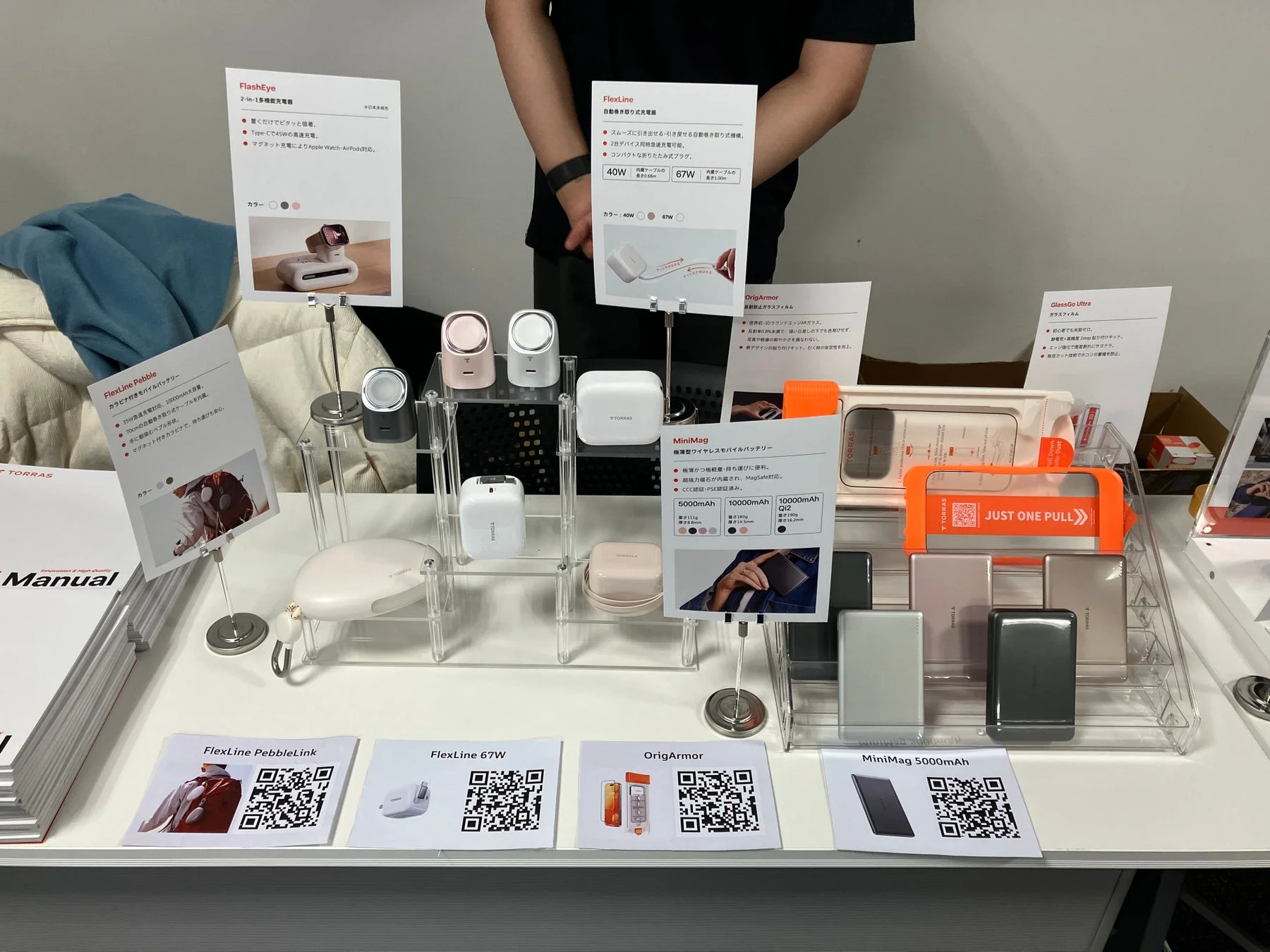 TORRASブランドの多機能充電器、自動巻き取り式充電器、モバイルバッテリー、ガラスフィルムなどのスマートフォンアクセサリーが展示されているブースの様子。