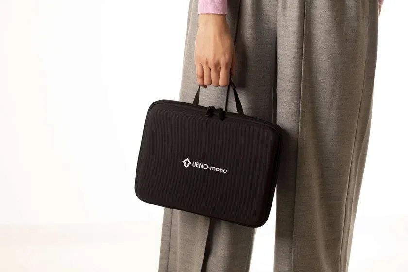 キャリーケースを手に持つ人物