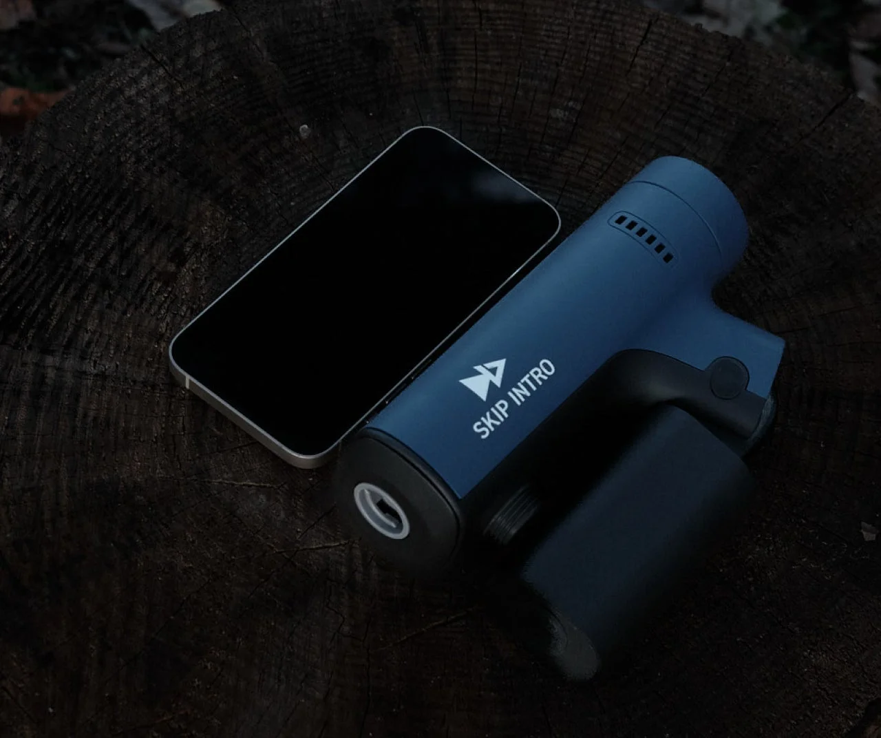 木製の切り株に置かれたスマートフォンと青いガジェット