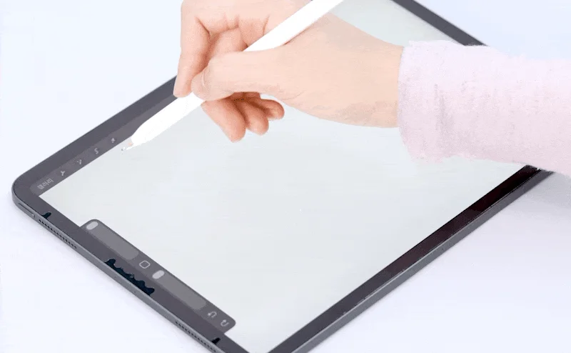 白いスタイラスペン（Apple Pencil）を使い、タブレット（iPad）の画面に描画している様子です。
