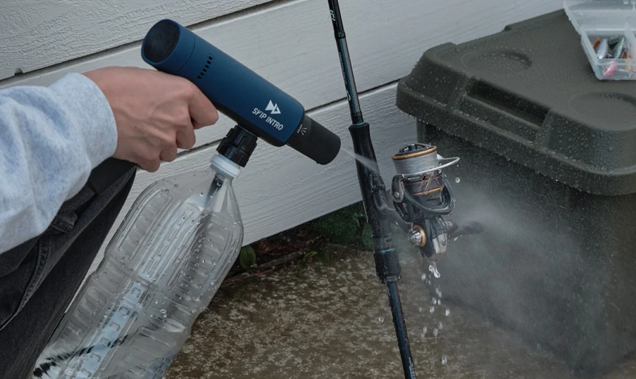 釣り竿とリールを携帯型洗浄機で清掃している様子