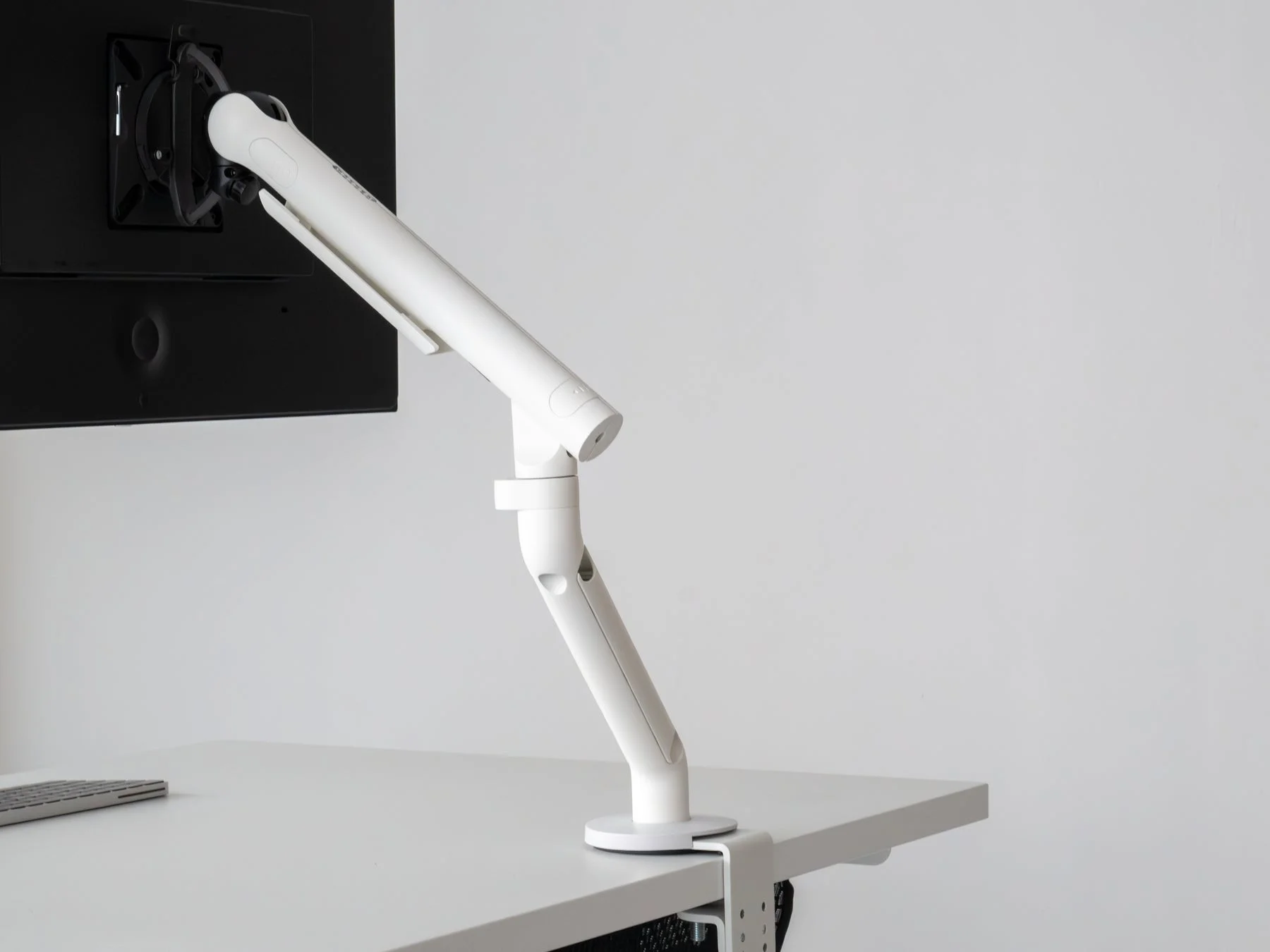 白いデスクに設置されたモニターアーム