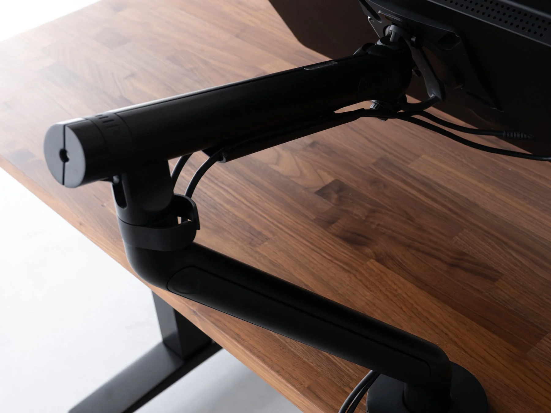 木製デスクに設置されたモニターアーム