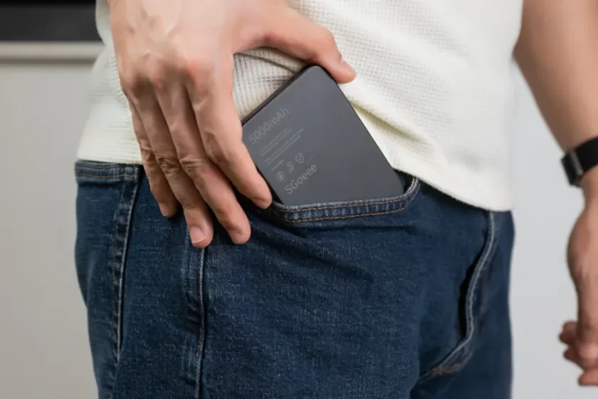 男性がモバイルバッテリーをジーンズのポケットに入れている様子