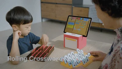 子供と大人が一緒に「Rolling Crossword」という知育ゲームで遊んでいる様子です。