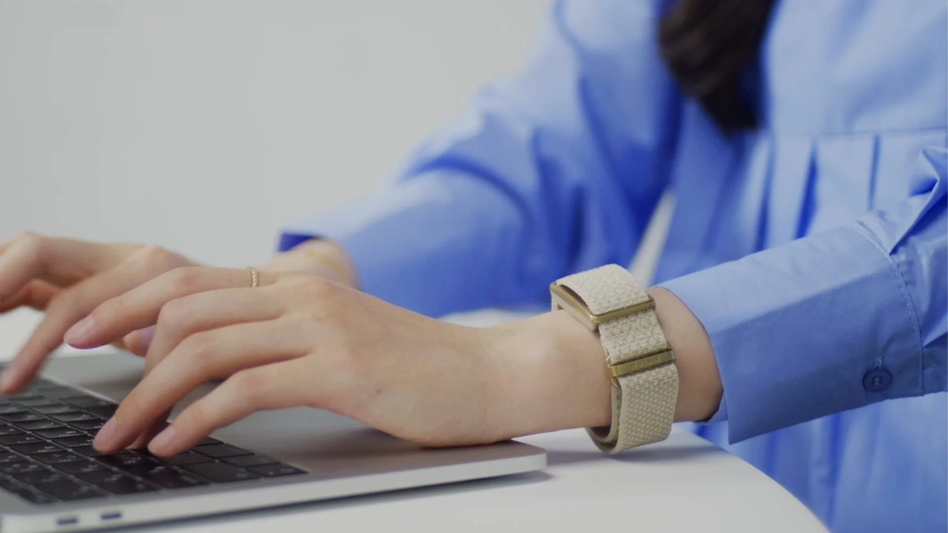 パソコンでタイピングする手元とスマートバンド