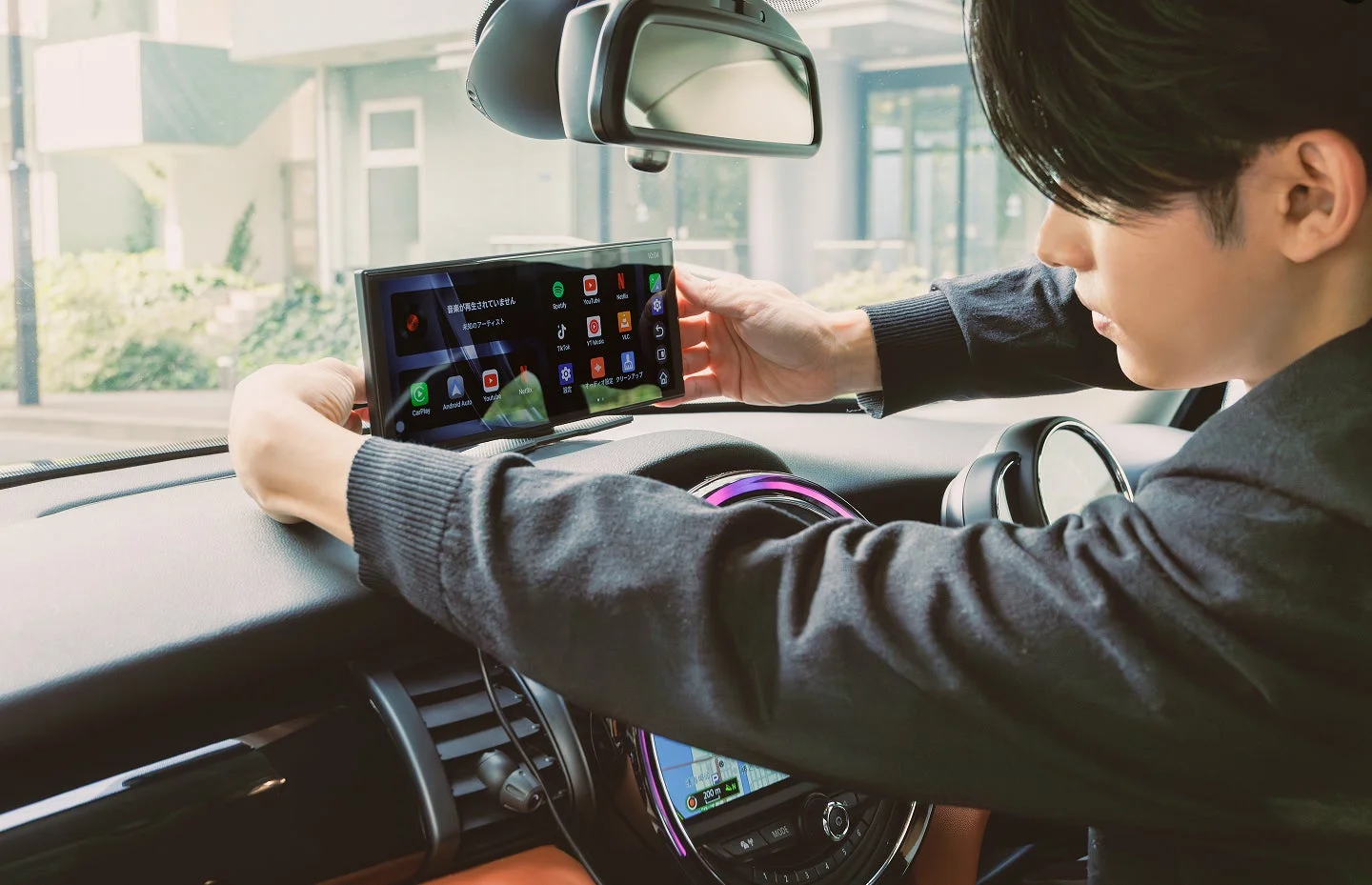 男性が車のダッシュボードにポータブル車載ディスプレイを取り付けている様子