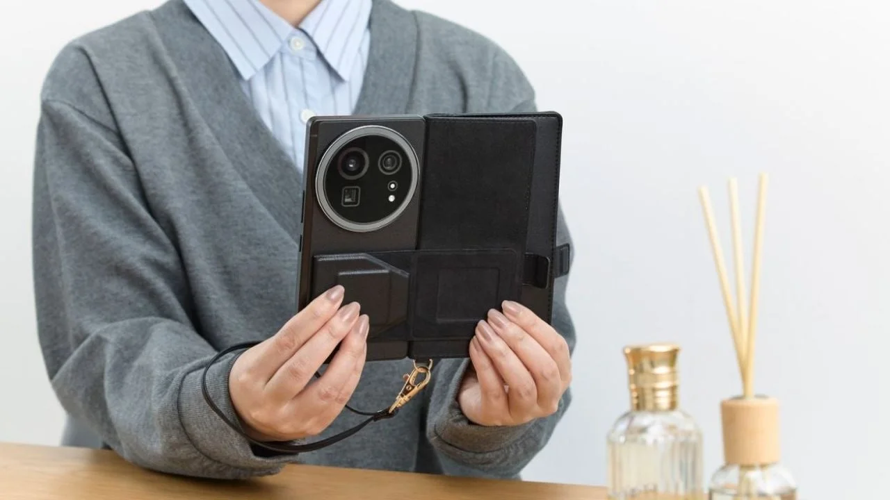 ハンドストラップ付きケースを手にした女性