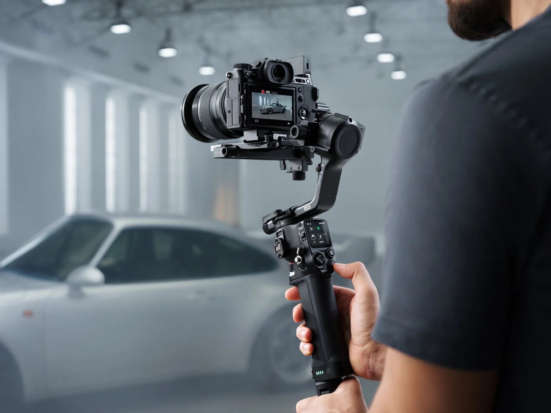 プロの撮影機材であるミラーレスカメラとジンバルを操作する人物