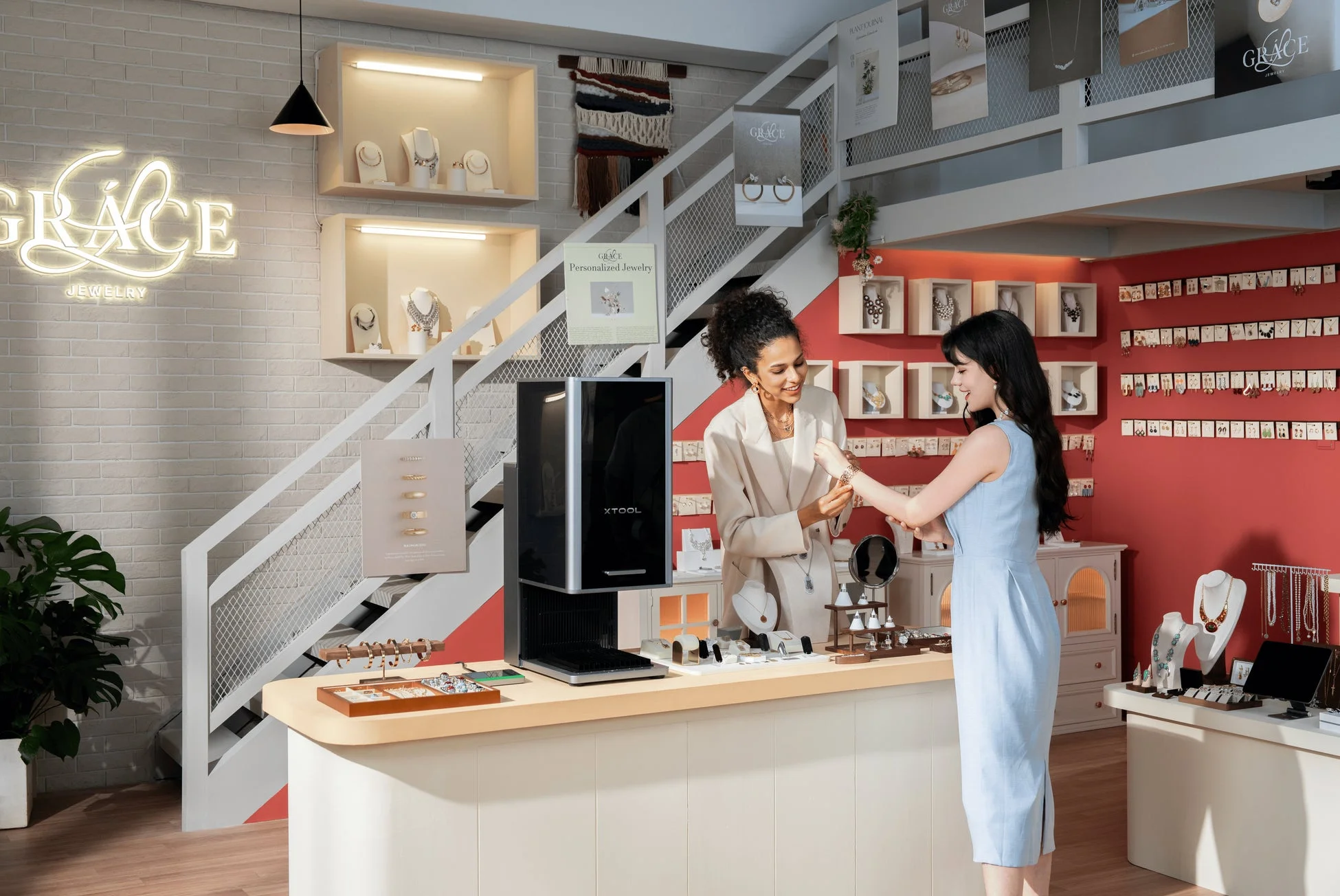 モダンなジュエリーショップで、店員が顧客にブレスレットを試着させている様子