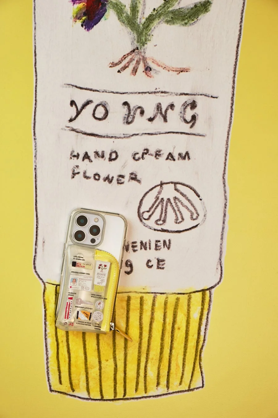 iPhoneケースと黄色いポーチ
