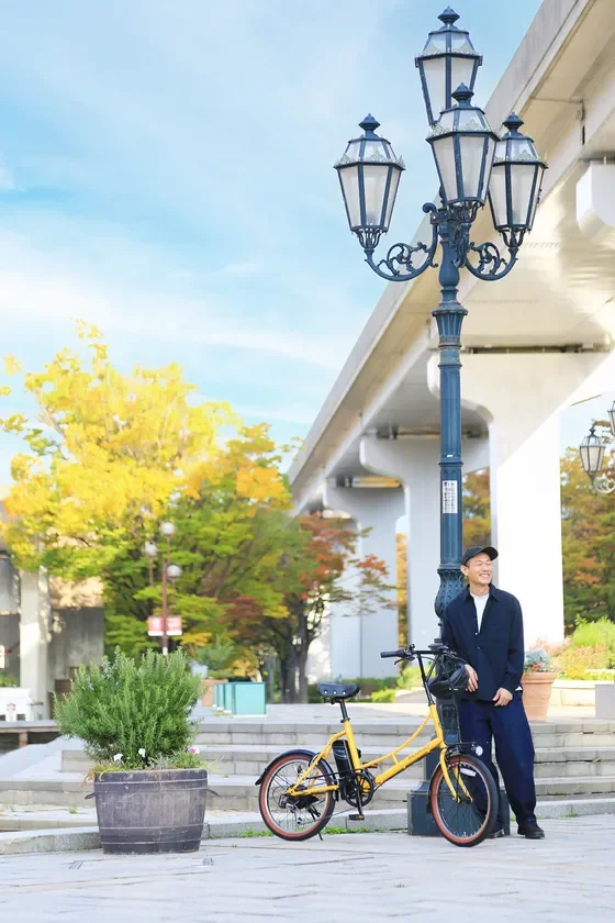 男性が黄色い自転車の隣に立つ