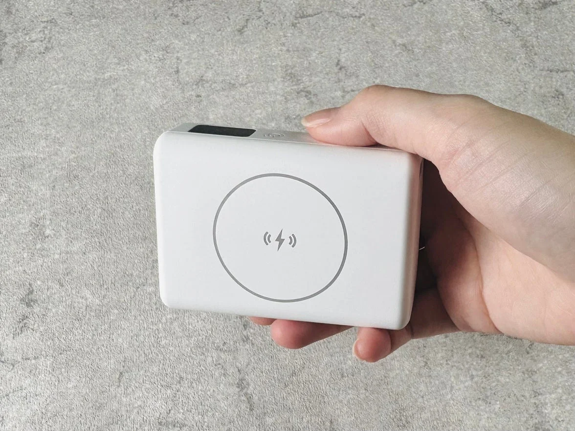ワイヤレス充電器を片手が持っている写真
