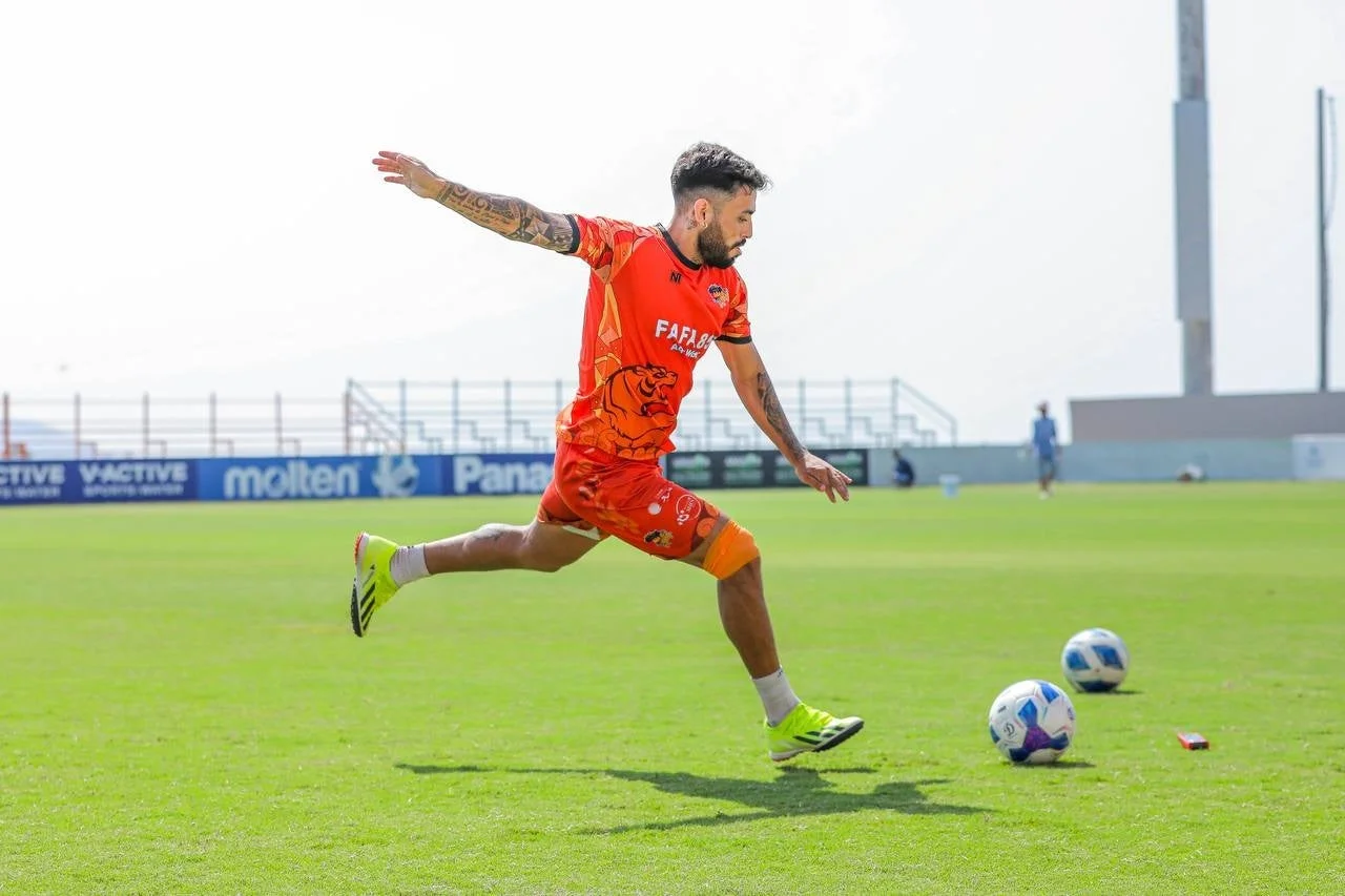 オレンジのユニフォームの選手がボールを蹴るポーズ