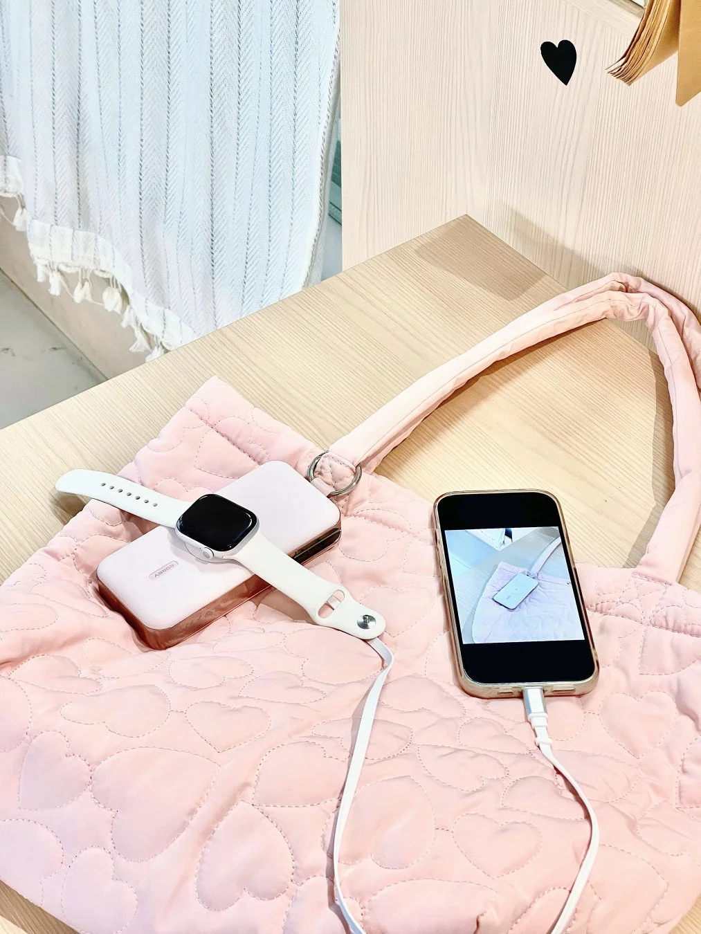 ピンクのキルティングバッグとモバイルバッテリー、スマホ、スマートウォッチ