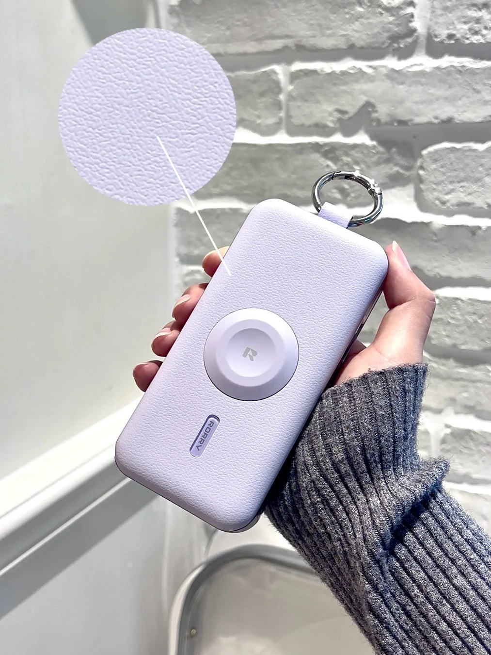 手で持っているラベンダー色のモバイルバッテリー