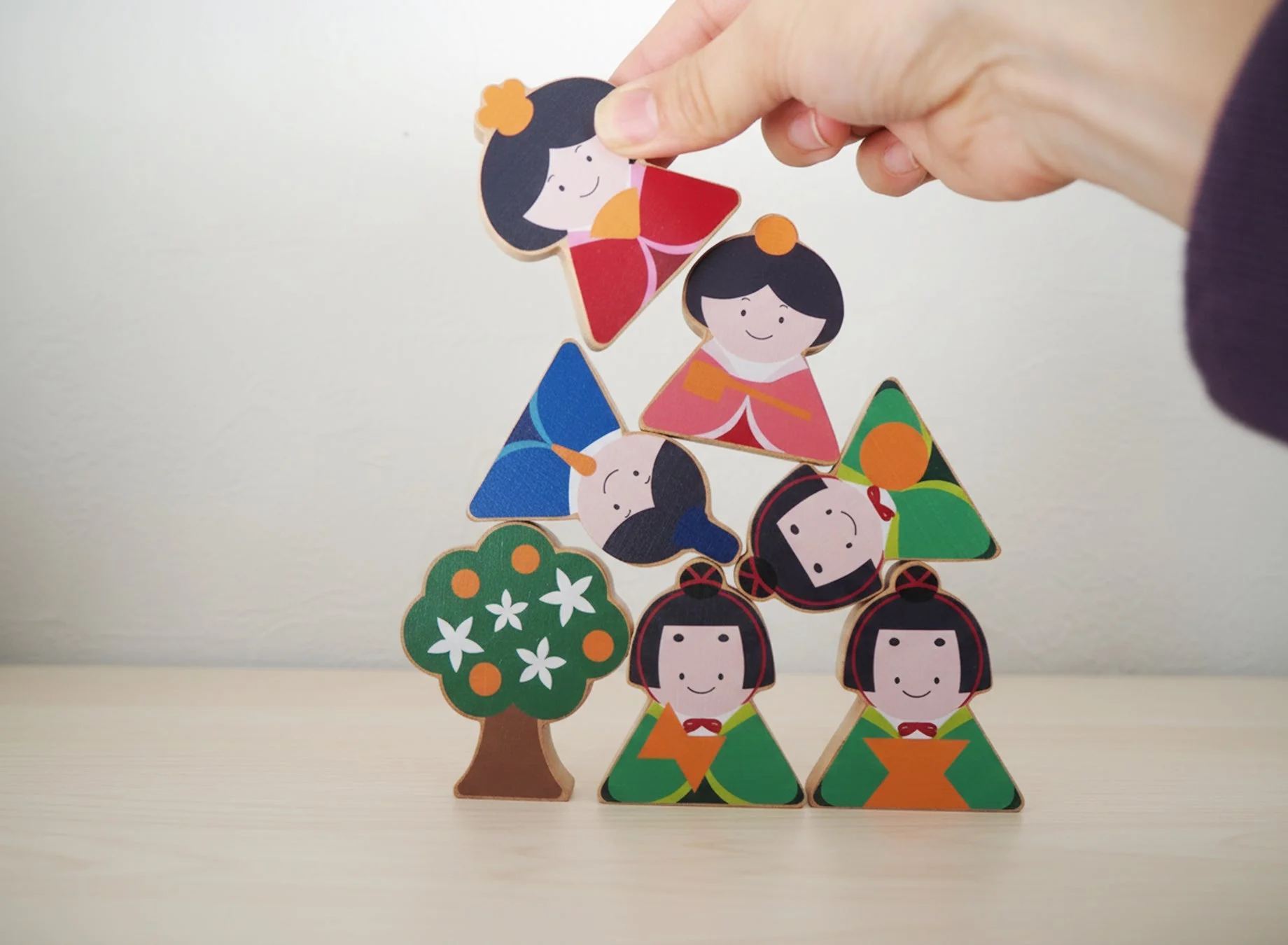 ひな人形の積み木を並べる手
