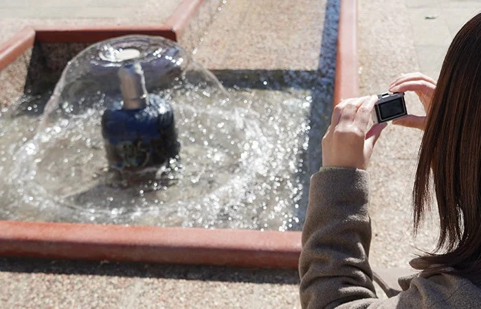 噴水を撮影する女性とカメラの画面