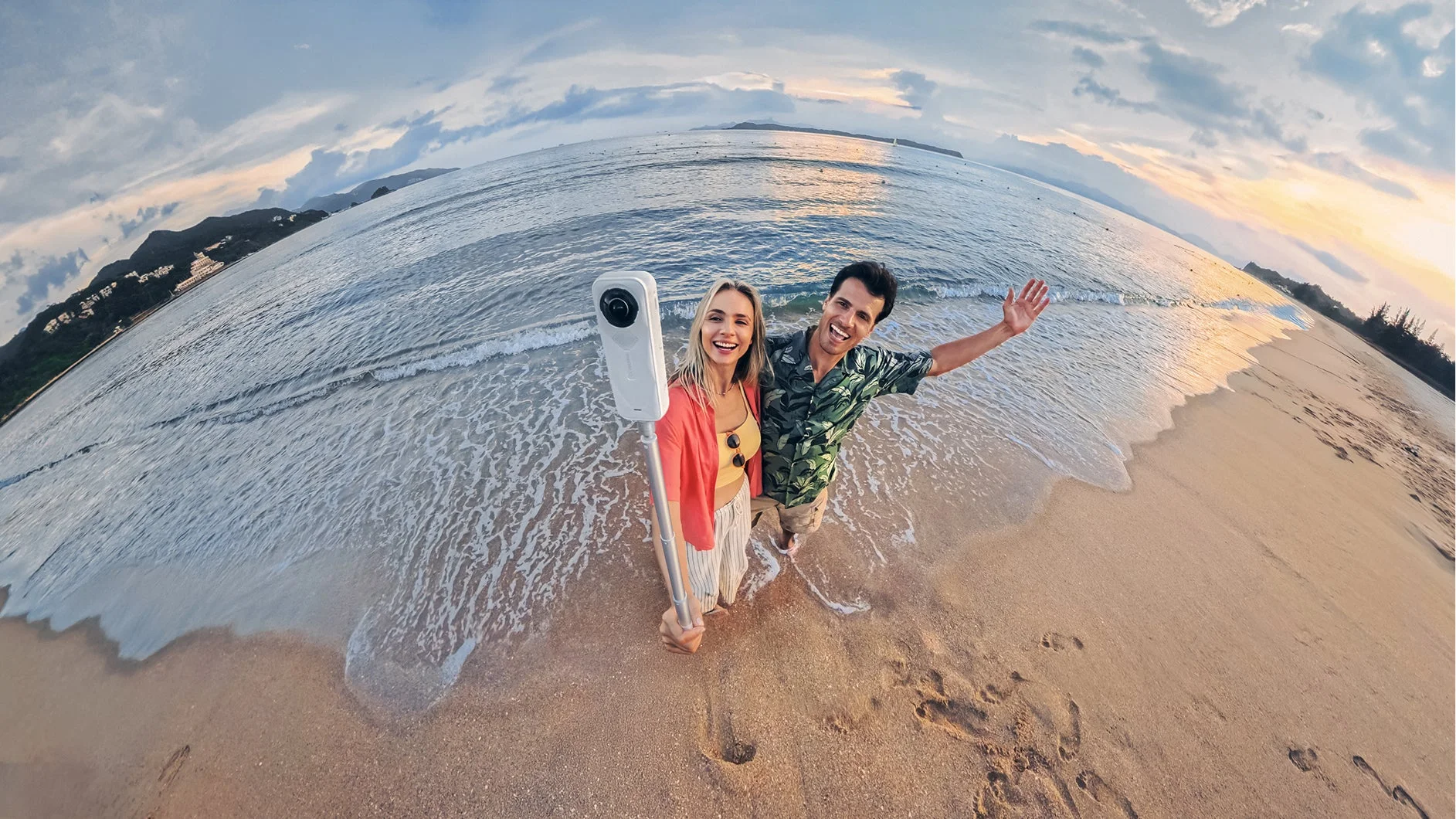 夕焼けのビーチでInsta360カメラを使うカップル
