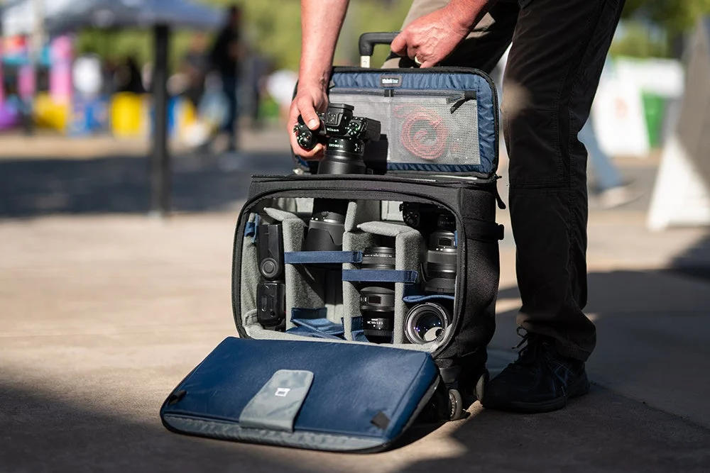シンクタンクフォトのキャリーバッグを開ける男性の画像