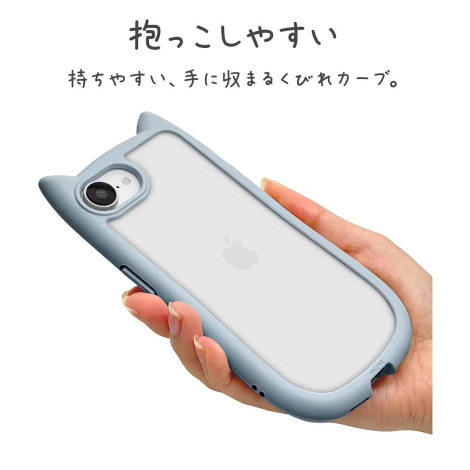 女性の手が、猫耳デザインの淡い水色のiPhoneケースを装着したiPhoneを握っています。ケースは「抱っこしやすい」「持ちやすい、手に収まるくびれカーブ」と説明されており、人間工学に基づいたデザインが特徴です。