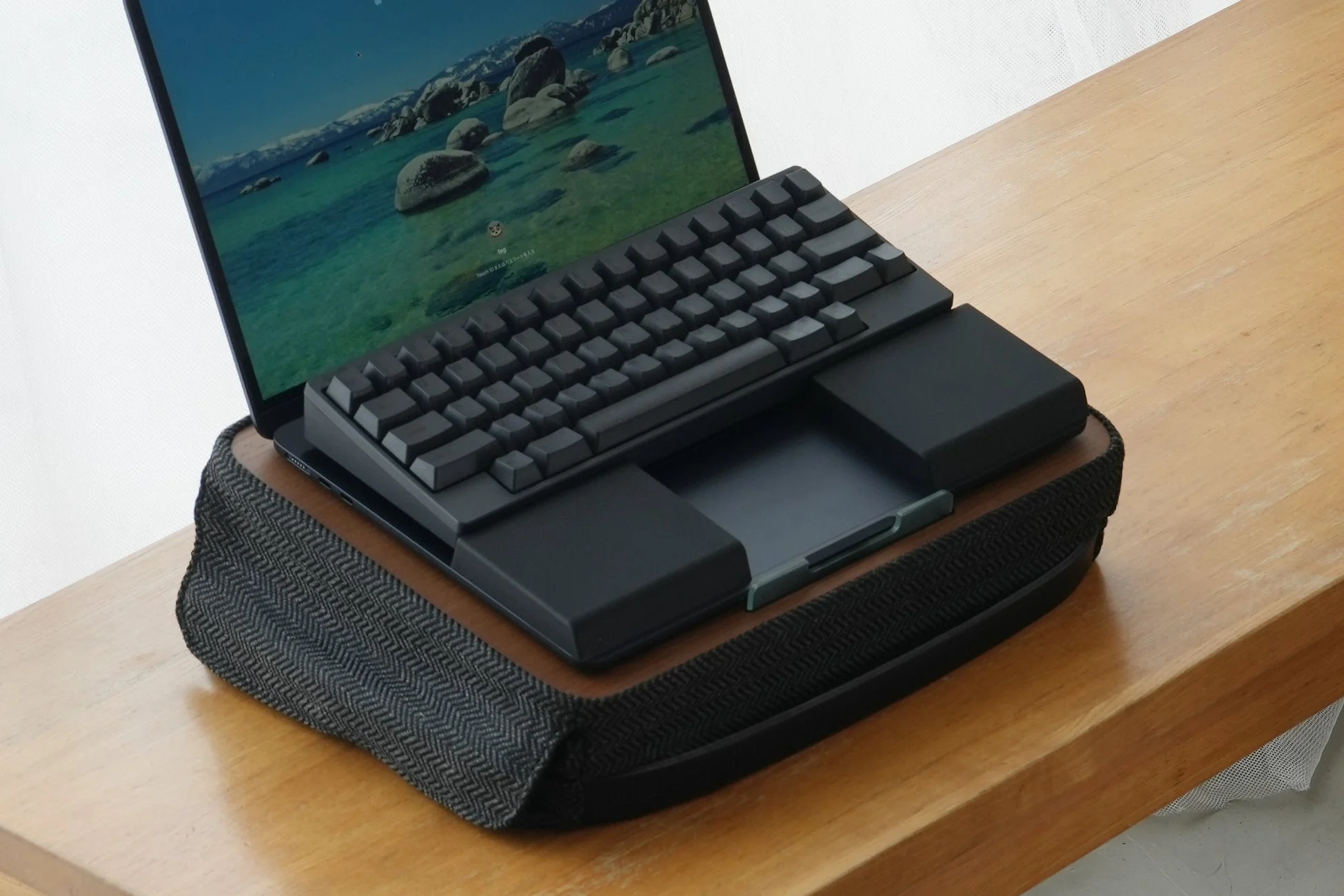 木製の机の上にノートパソコンと外付けキーボードが設置されたワークスペース