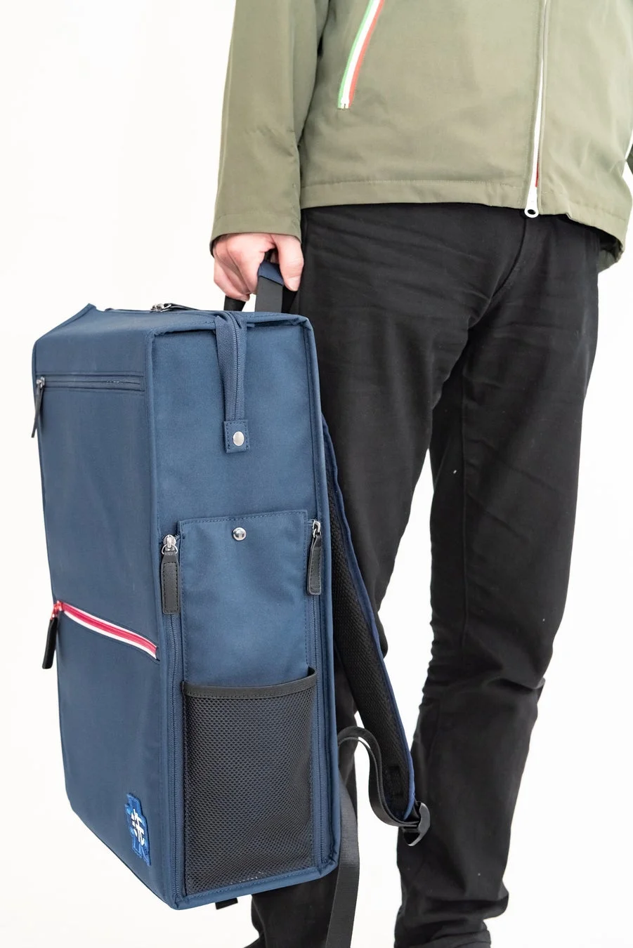 バックパックを手で持つ男性