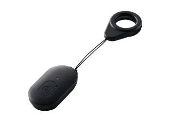 白い背景に置かれた黒いBluetoothカメラリモコンです。楕円形のリモコン本体にはカメラアイコンのボタンがあり、ストラップで指に装着できるリングが付いています。自撮りや集合写真の撮影に便利な小型の電子機器です。