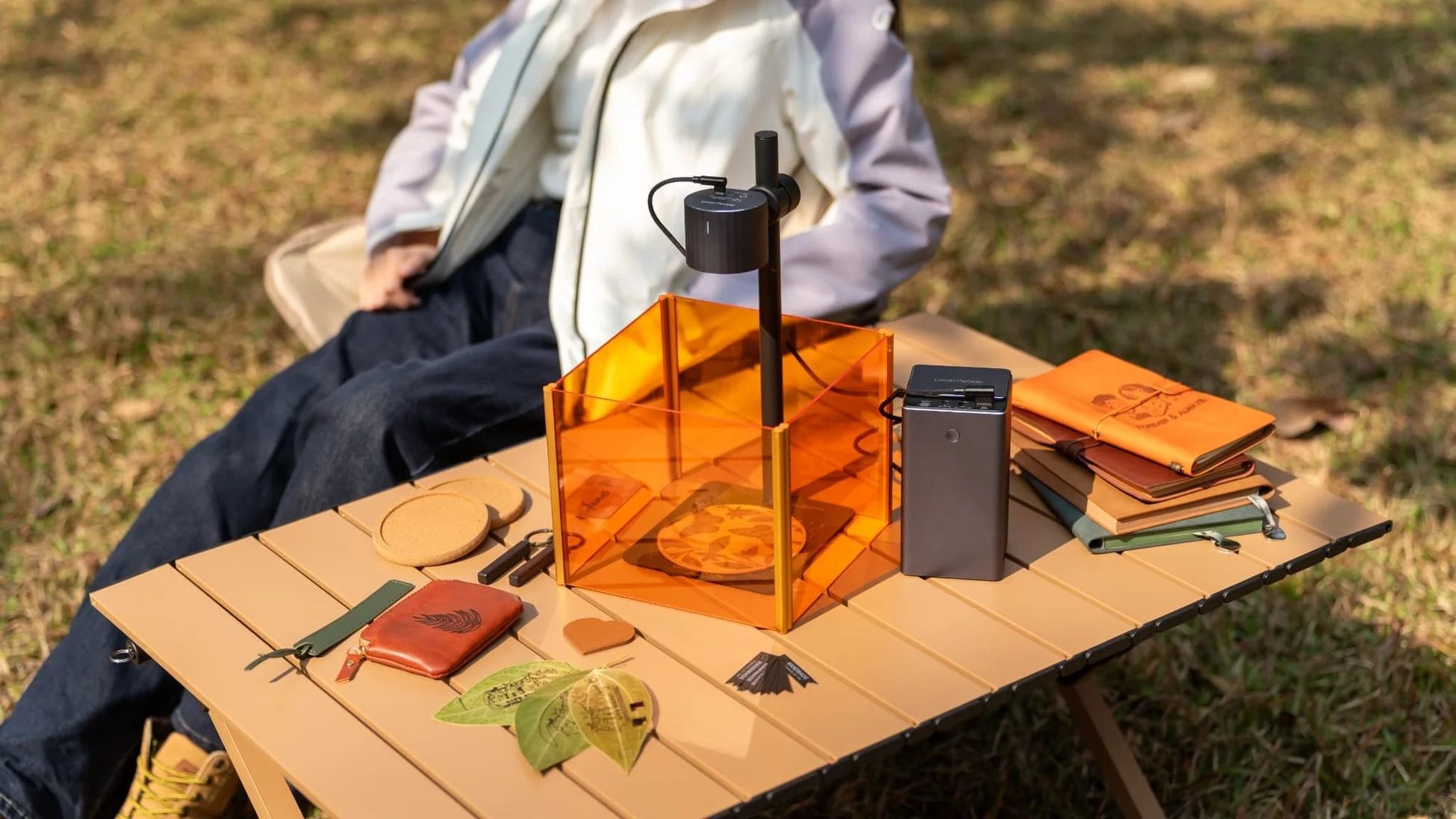 屋外でレーザー彫刻機を使って小物を製作している様子