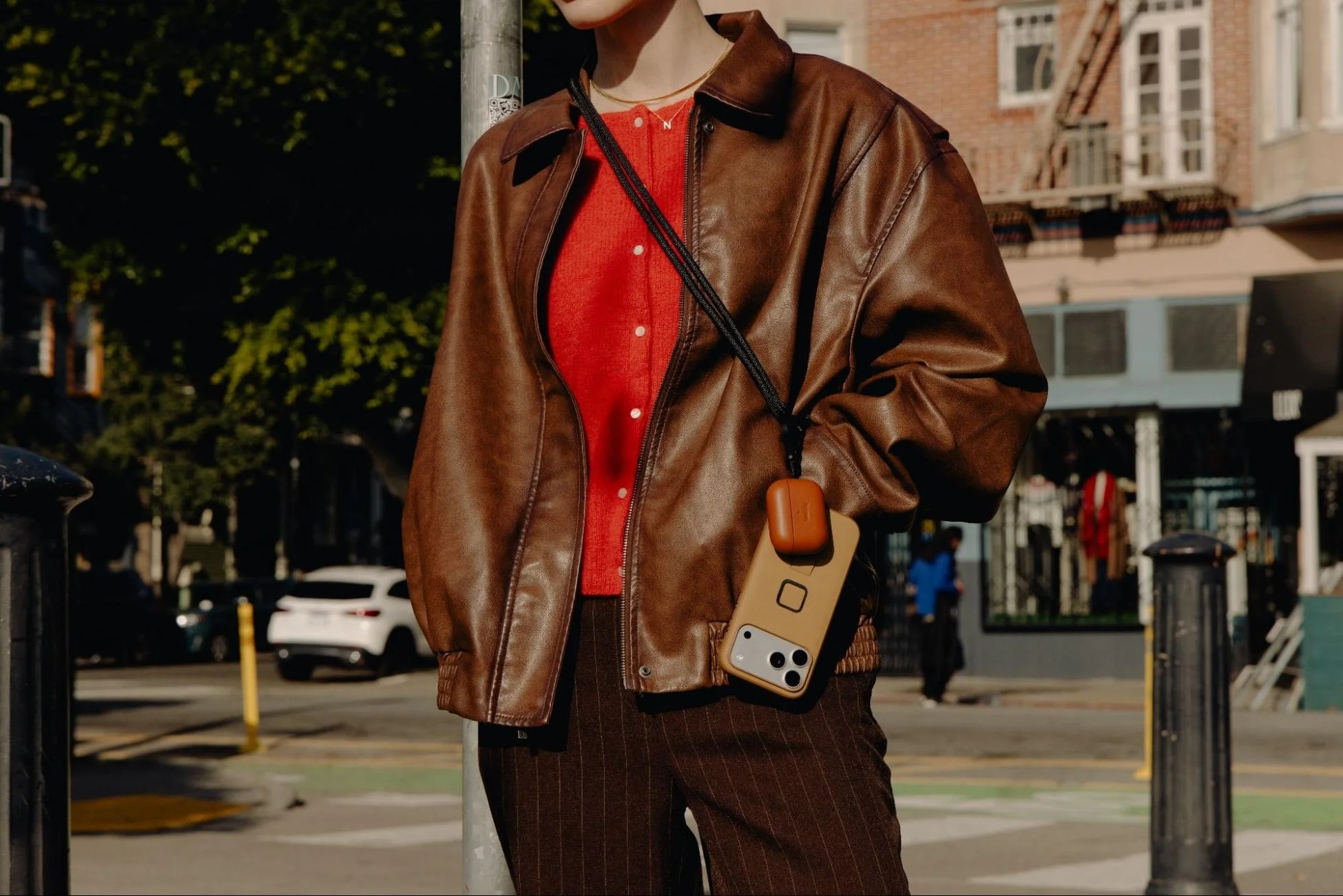 スマホとAirPodsケースをストラップで身につけた様子