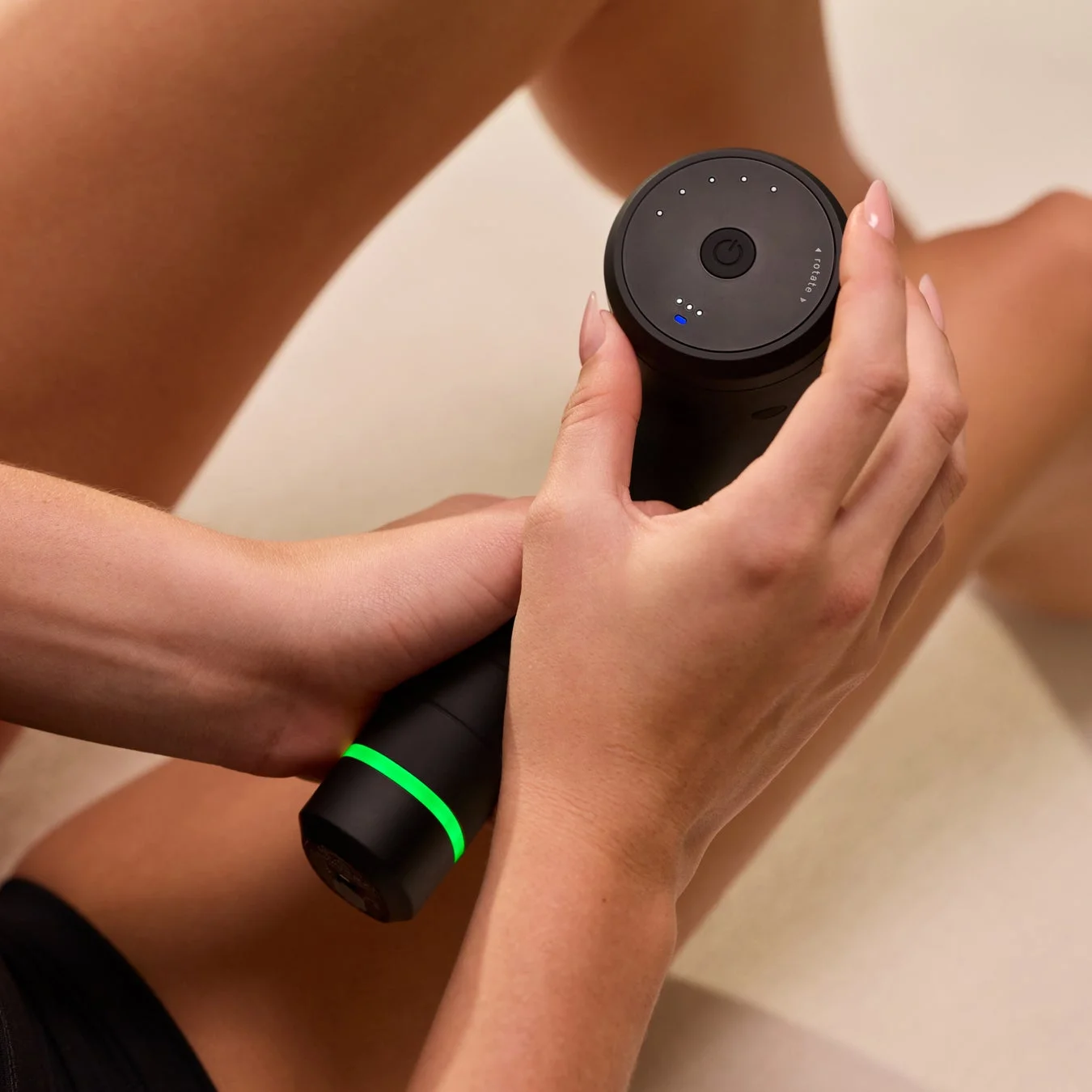 マッサージガンで脚をケアする女性