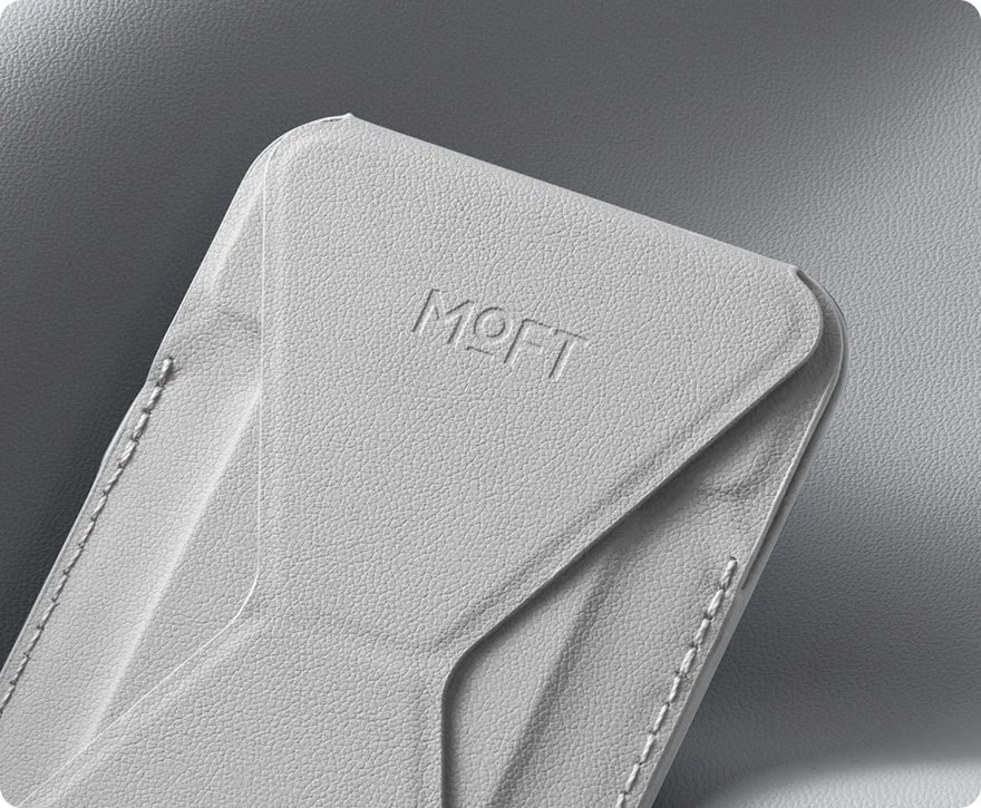 MOFTのロゴがエンボス加工された、折りたたみ式のグレーのスマートフォンアクセサリー