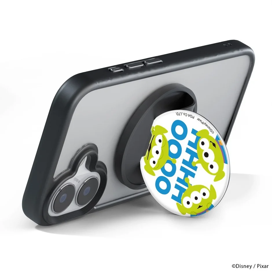 トイ・ストーリーのリトルグリーンメンがデザインされたスマホグリップが取り付けられたスマートフォンが横向きに立てられています。