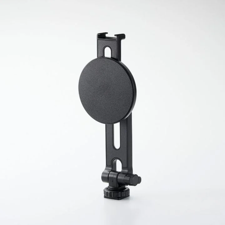 白い背景に置かれた黒いスマートフォンホルダーです。上部にはスマートフォンを挟む部分があり、中央には円形のマグネットまたは取り付けプレートが見えます。下部にはコールドシューマウントがあり、様々な撮影機材に取り付け可能です。
