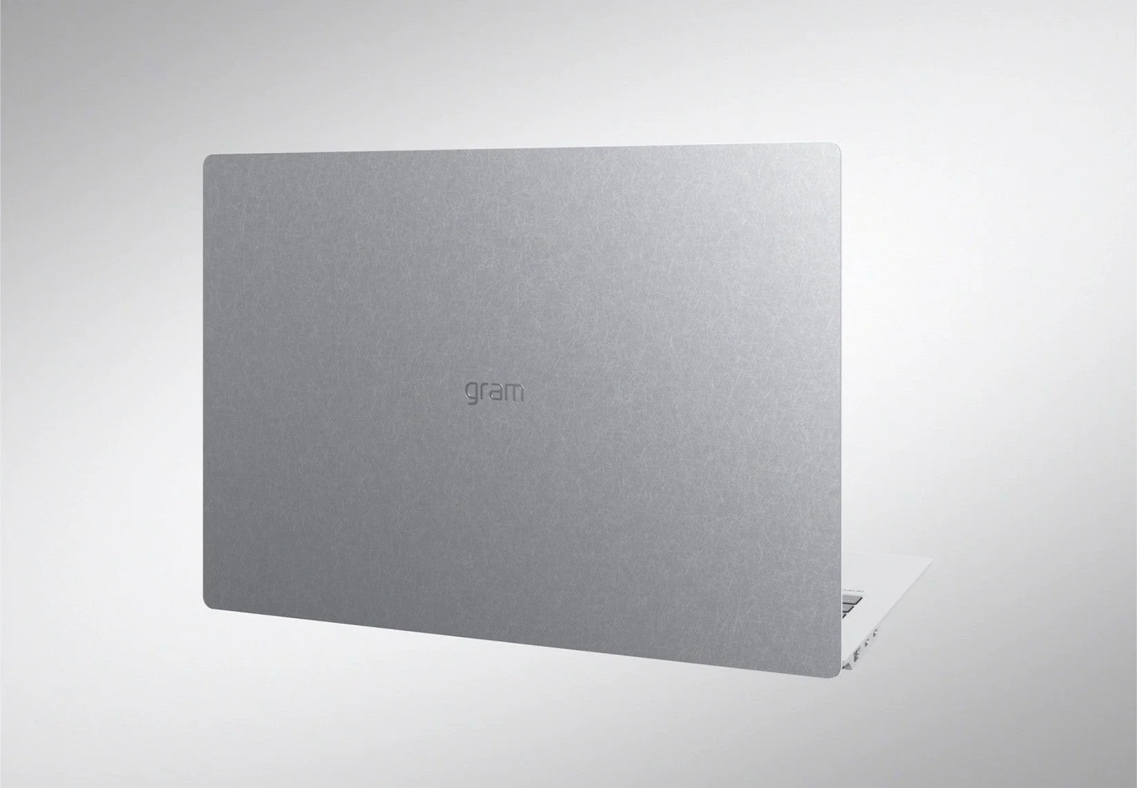 銀色のノートパソコンの背面が写っており、中央には「gram」のロゴがエンボス加工