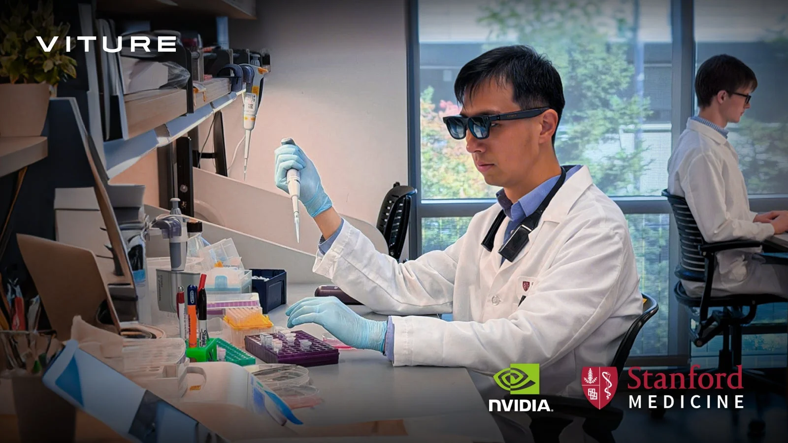 研究室で白衣を着た科学者がARグラスを装着し、ピペットを使って実験を行っています。NVIDIAとStanford Medicineのロゴがあり、医療研究における先進技術の活用を示唆しています。