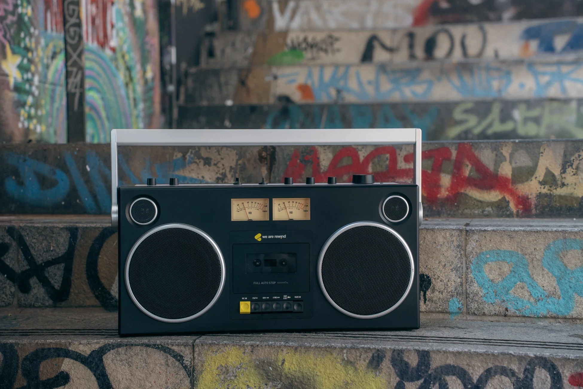グラフィティが描かれたコンクリートの階段に置かれた黒いレトロなラジカセ
