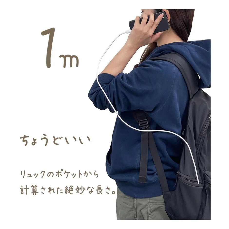 リュックを背負った女性がスマートフォンを充電している様子