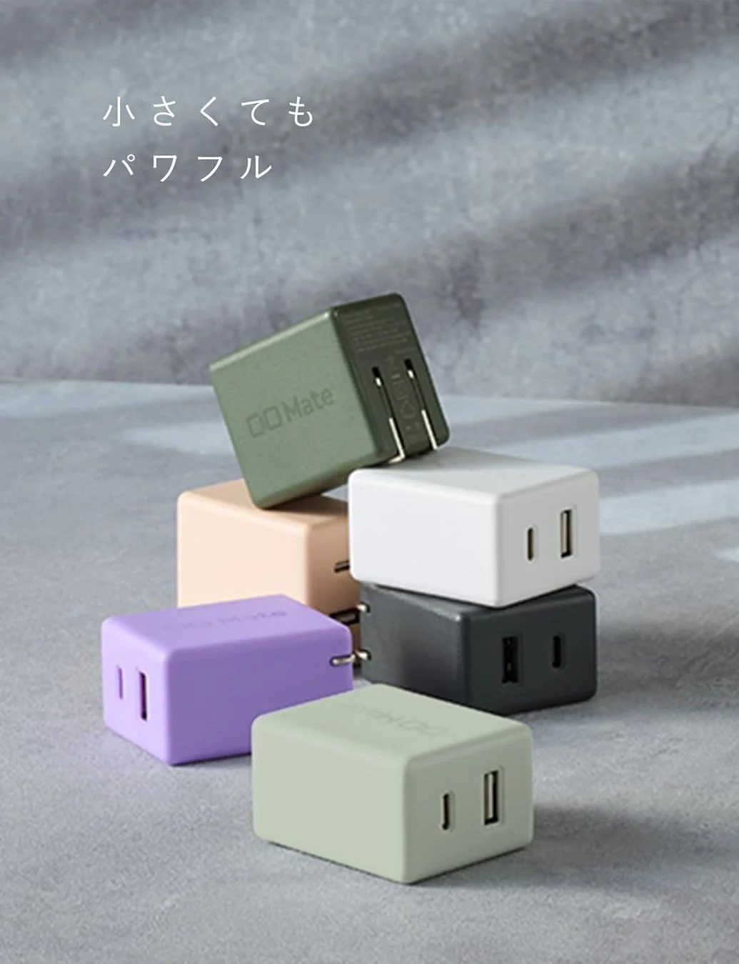 様々な色（カーキ、ベージュ、白、黒、紫、薄緑）のコンパクトなUSB充電器が複数積み重ねて配置されています。