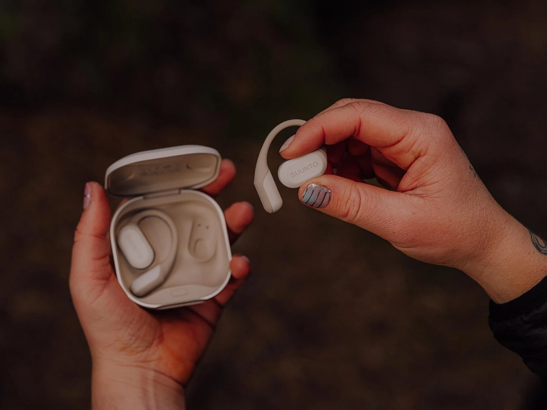 Suunto Sparkイヤホンと充電ケースを持つ手