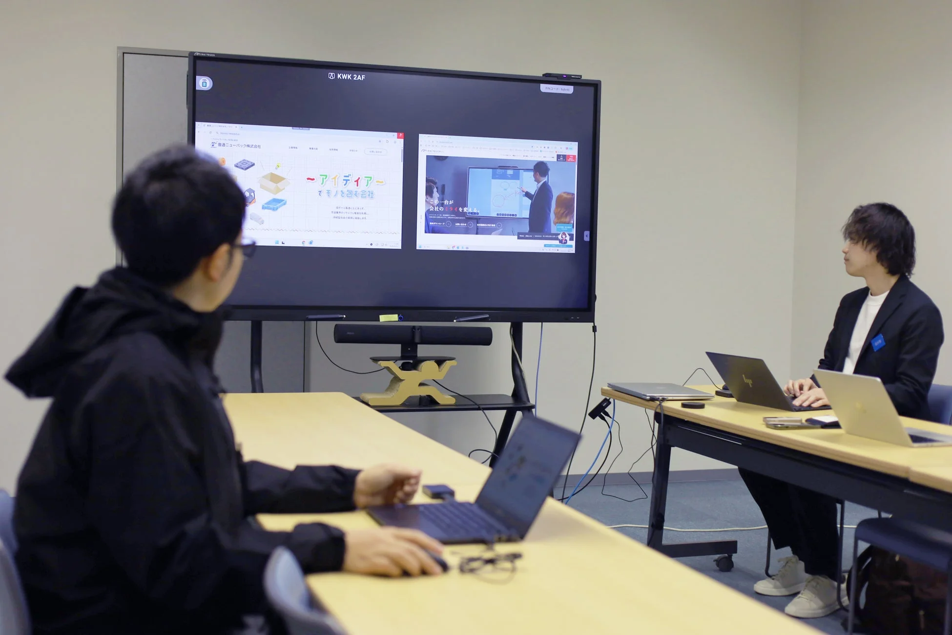 会議室でディスプレイを見る男性たち