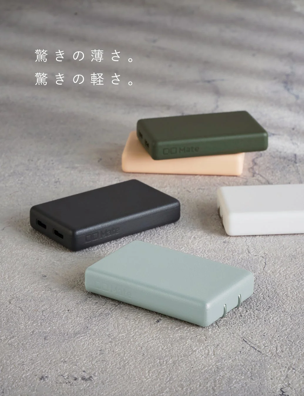 複数の薄型で軽量なモバイルバッテリー「GO Mate」が、様々なカラーでコンクリート調の背景に配置されています。