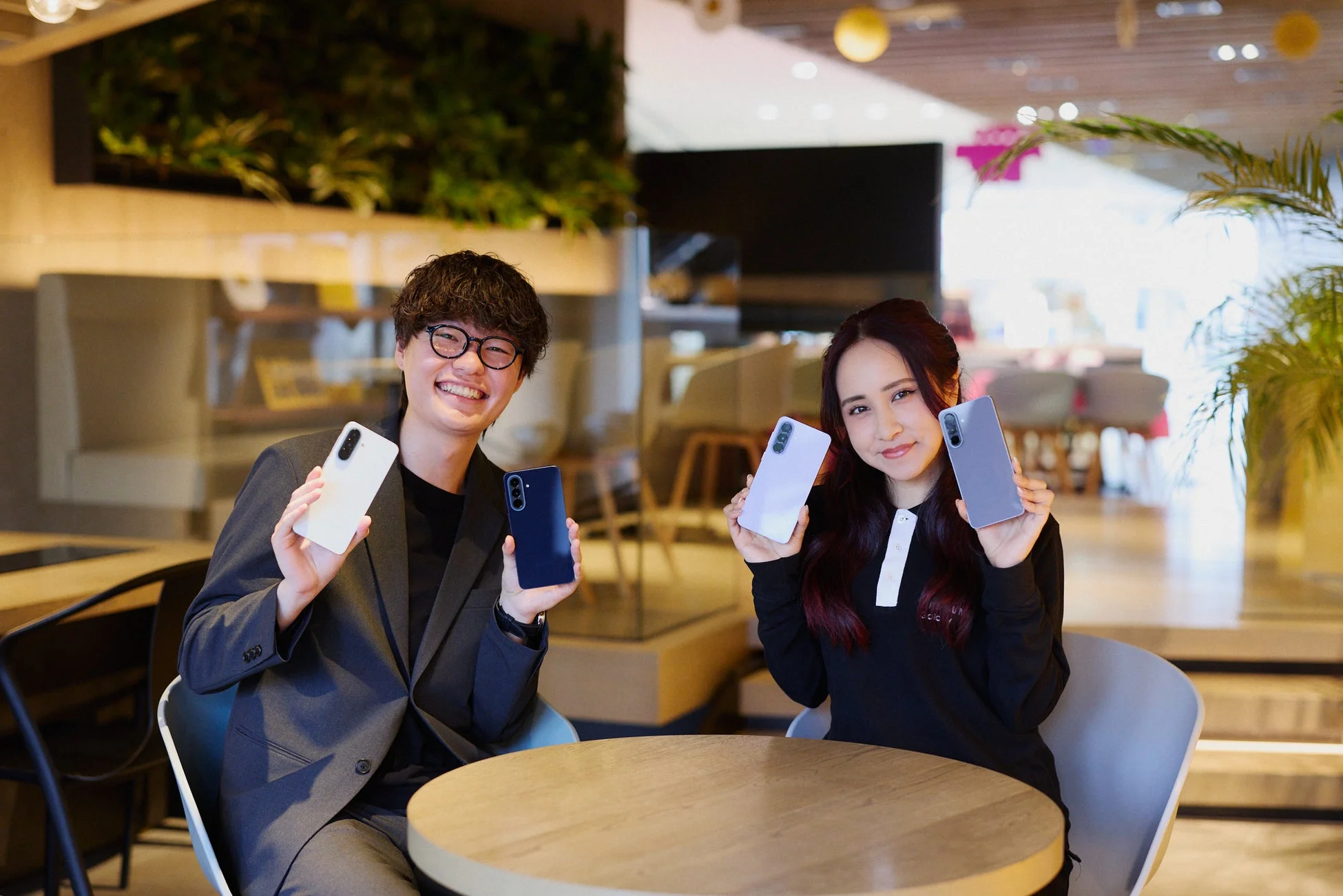 笑顔の男女と複数色のスマートフォン