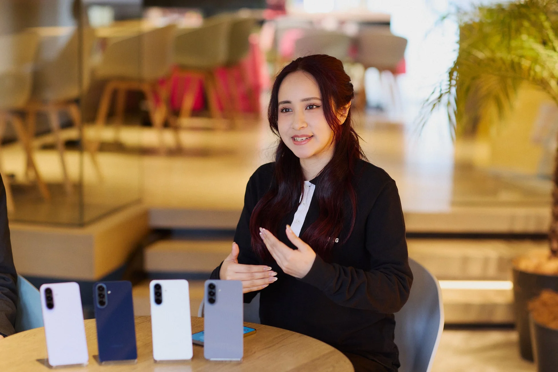 女性がスマートフォンについて説明している画像