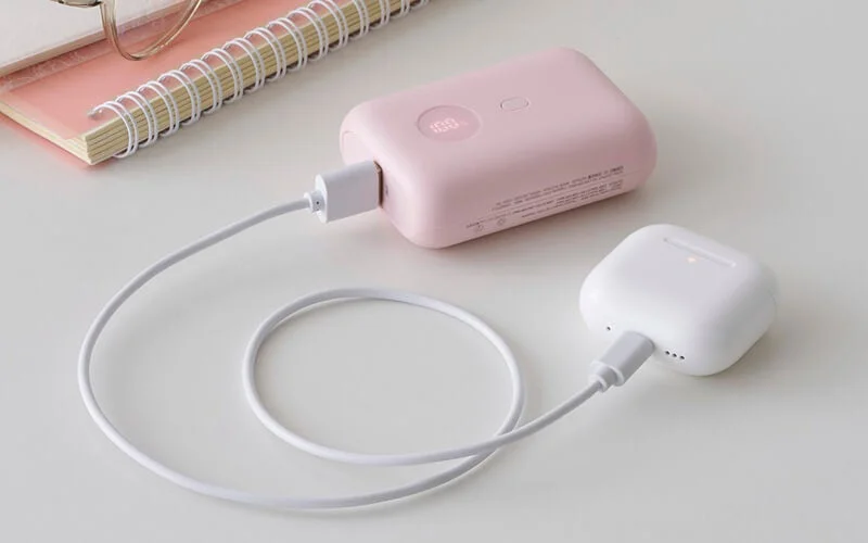 ピンクのモバイルバッテリーでAirPodsケースを充電している様子