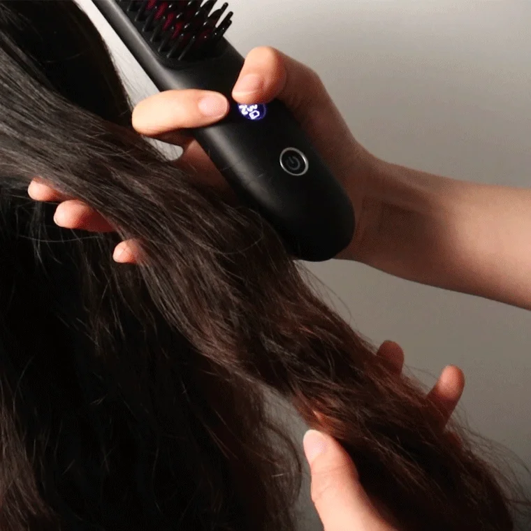 女性がヘアアイロンブラシを使用